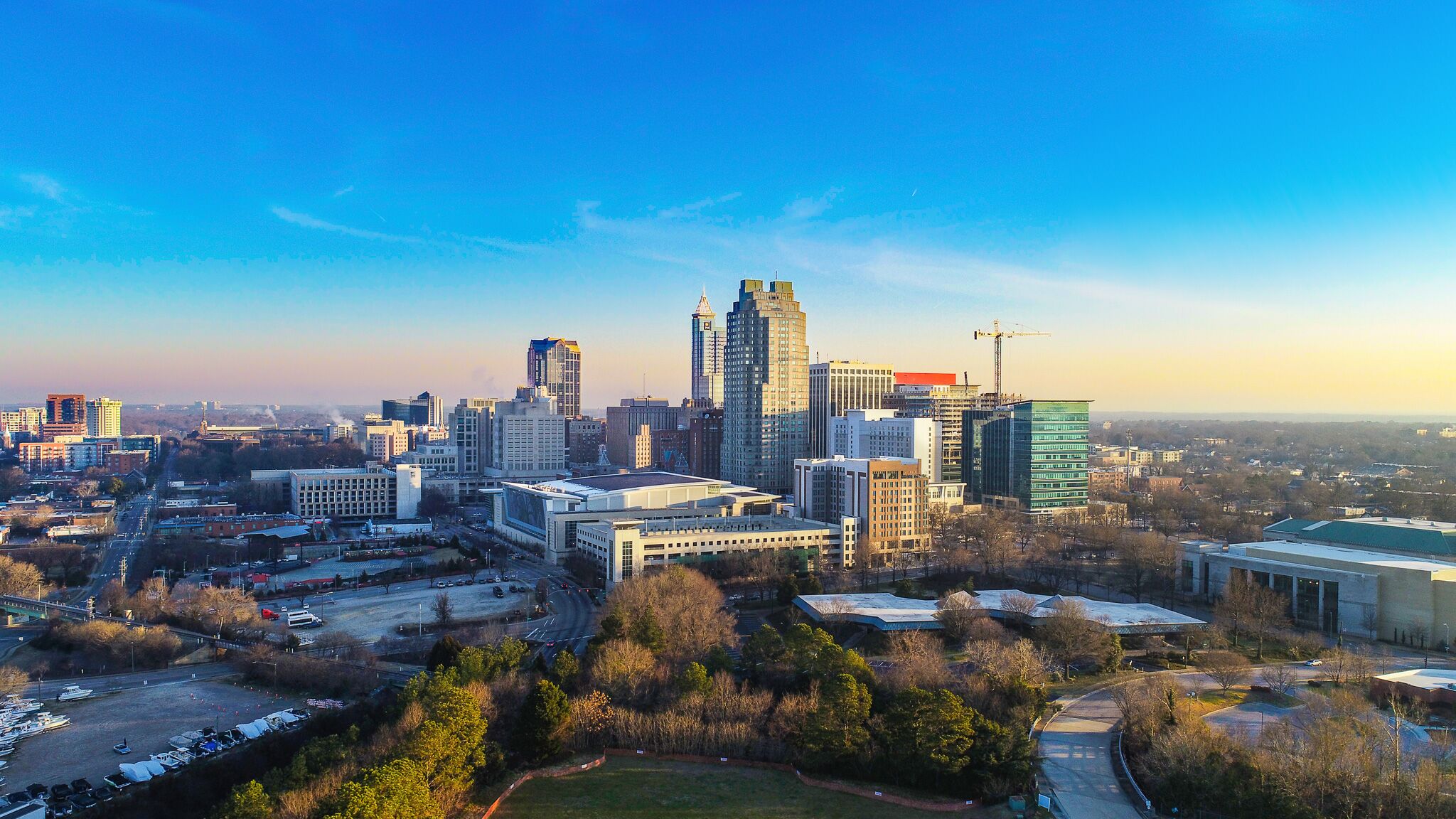 An aerial view of the downtown Raleigh skyline at golden hour, the heart of North Carolina's Triangle.